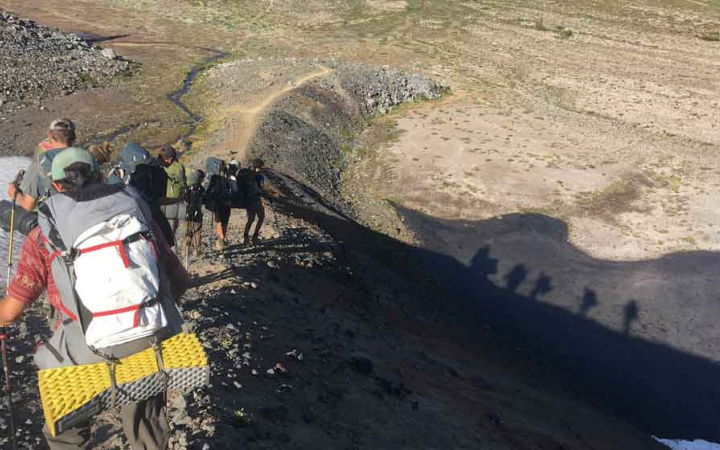 a group of students descend a rocky landscape on an outward bound course